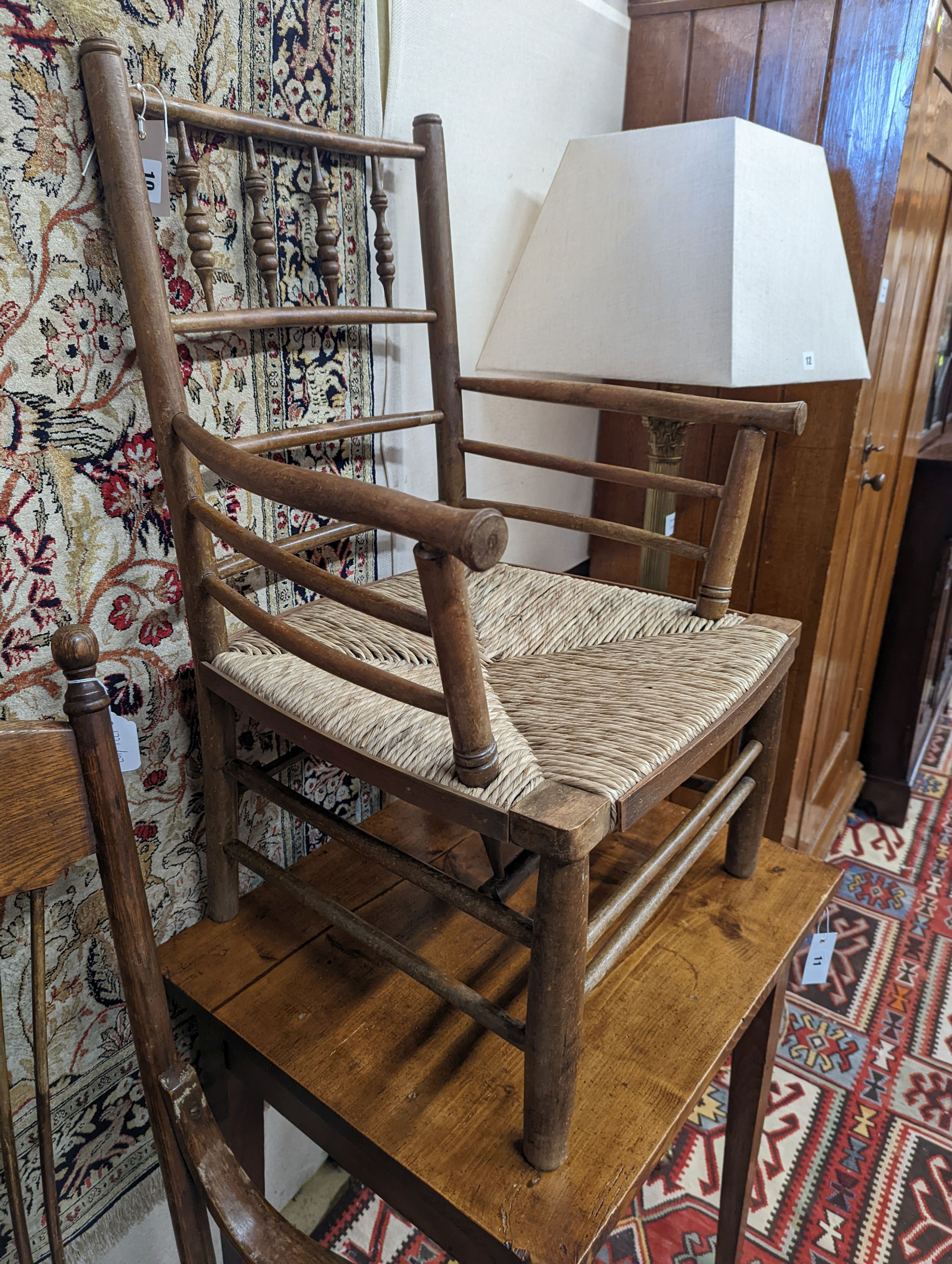 A late 19th century beech rush seated Sussex elbow chair, (cut down) width 55cm, depth 44cm, height 81cm